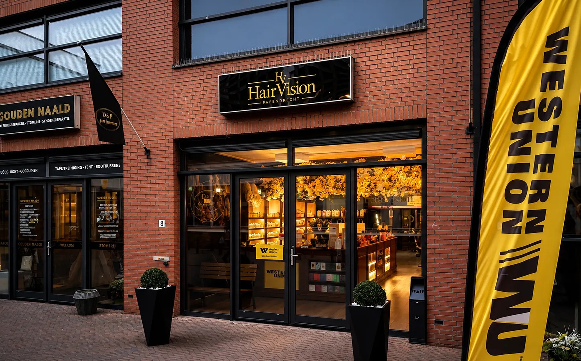 De verlichte etalage van HairVision in de Overtoompassage, 's avonds